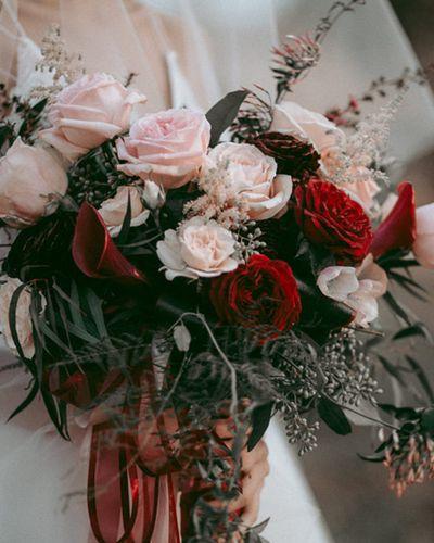 Bridal bouquet, bride’s bouquet with flowers done by Sweet Elegance Floral design florist in Kelowna, BC. Hand tied moody, dark bouquet with roses, calla lilies, garden roses and spray roses, in pink, red and deep purple.