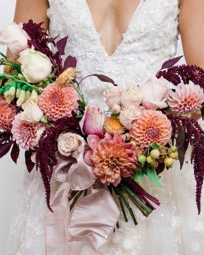 Bridal bouquet, bride’s bouquet with flowers done by Sweet Elegance Floral design florist in Kelowna, BC. Hand tied bouquet with roses, dahlias, amaranthus in pink, peach, cream and orange florals accented with pink satin ribbon.