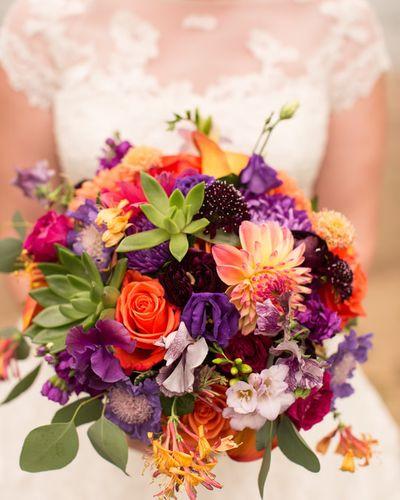 Bridal bouquet, bride’s bouquet with flowers done by Sweet Elegance Floral design florist in Kelowna, BC. Hand tied bouquet with roses, lisianthus, dahlias, roses and sedums in bright colours of orange, purple, pink, yellow and green.