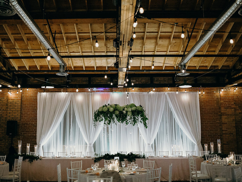 Wedding of Bride Ashlea and Groom Mark, reception at The Laurel Packinghouse in Kelowna, BC.  Hanging floral installation of green hydrangea, eucalyptus and greenery with floating candles.  Wedding photos taken by Tara Peach Photography.  Wedding flowers done by Sweet Elegance Floral design, florist in Kelowna, BC.  Featured in Rocky Mountain Bride Magazine.